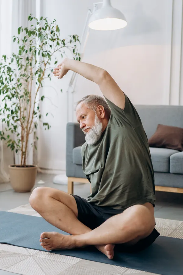 Senior man stretching gently at home during his morning routine